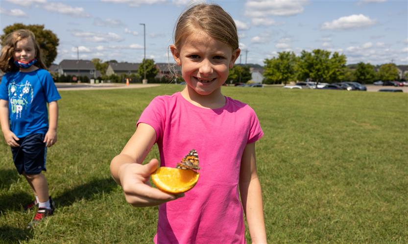 Students smile while releasing butterflies outside